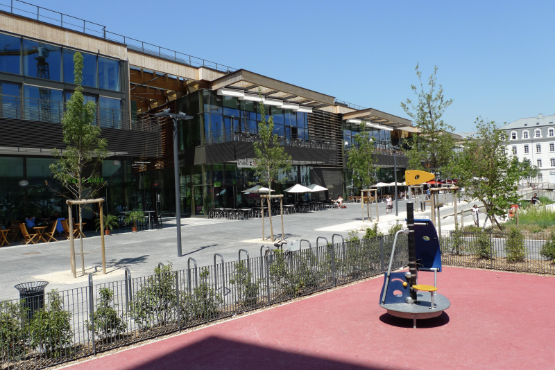Illustration - Vue du centre commercial depuis le cœur du parc de Bonne – angle jeux d’enfants